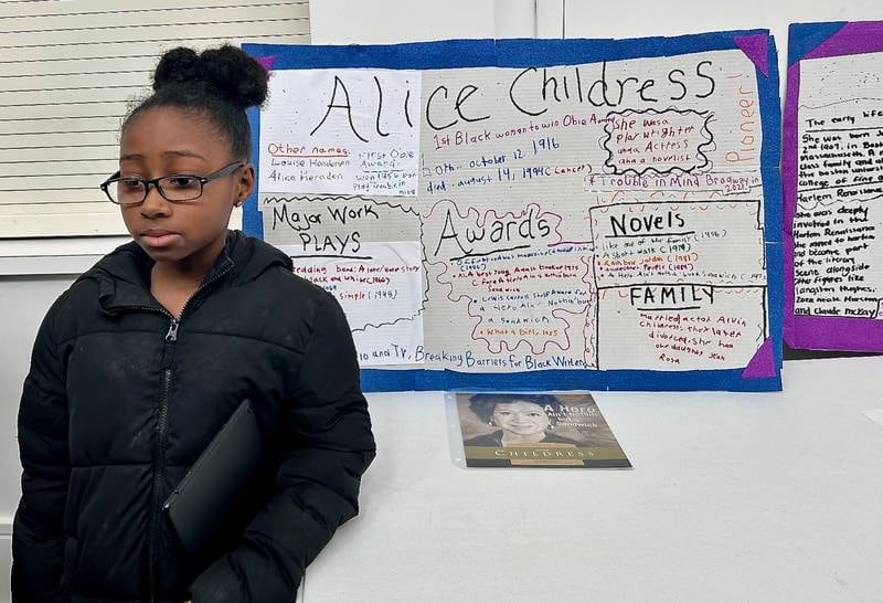 Mia Wood stands next to her work on author and playwright Alice Childress on Sunday, Feb. 16, 2025, at New Hope Missionary Baptist Church in DeKalb. The presentation was part of the church's annual Black History Month event "Displays of Excellence.”