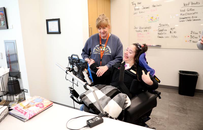Deanne Dahlquist, a paraprofessional for the St. Charles School District 303 Transition Program, works with Maya Donis at the Daily Bean coffee shop at the St. Charles Public Library.