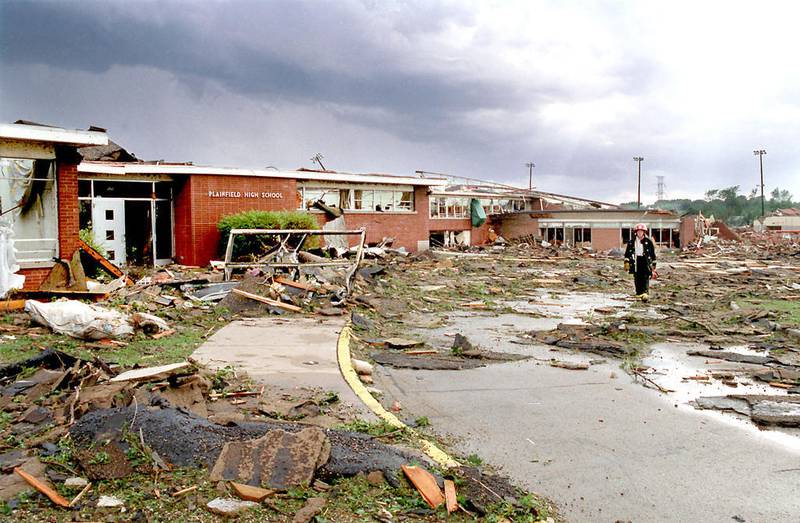 A rescue worker walks through the devastation at Plainfield High School, which was hit by the tornado that spun through the village Aug. 28, 1990. Two fatalities were reported at the school and one nearby in the administration building.