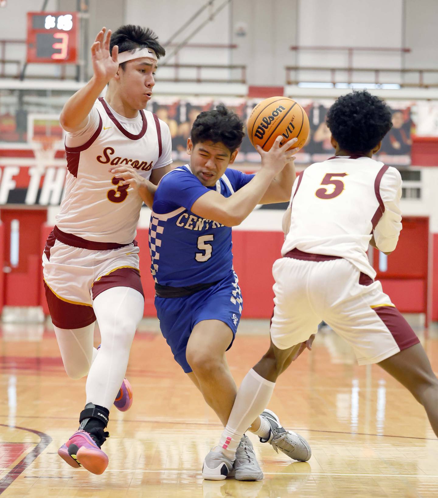 CentralÕs Cedric Ceniza (5) splits SchaumburgÕs Ray Black (3) and Aiden Patterson (5) on his way to the hoop during the Hinsdale Central Holiday Classic basketball tournament Friday, Dec. 26, 2025 in Hinsdale.