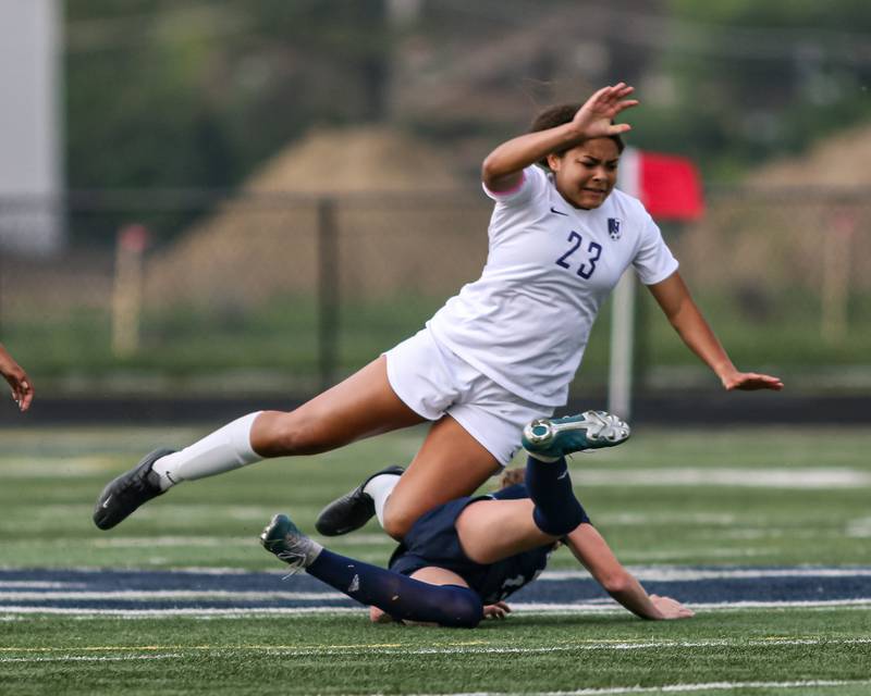 Downers Grove North's Kaitlyn Parker (23) is rolled by Downers Grove South's Emily Petring (13) during Class 3A Addison Trail Regional final soccer match between Downers Grove South at Downers Grove North.  May 19, 2023.