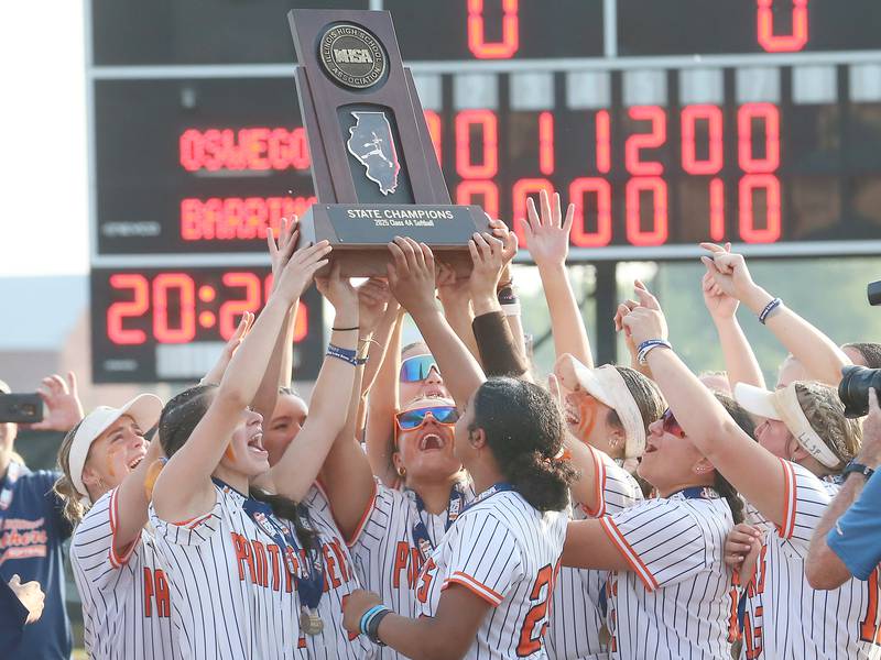 Members of the Oswego softball team hoist the Class 4A championship trophy after defeating Barrington on Saturday, June 14, 2025 at the Louisville Slugger Sports Complex in Peoria.