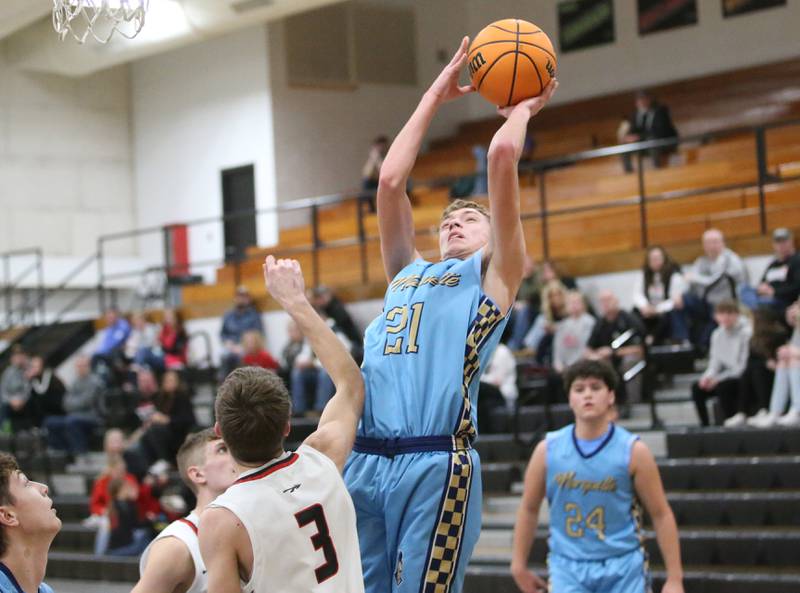 Marquette's Lucas Craig lets go of a shot over Woodland's Quentin Porter during the Tri-County Conference Tournament on Tuesday, Jan. 28. 2025 at Putnam County High School.