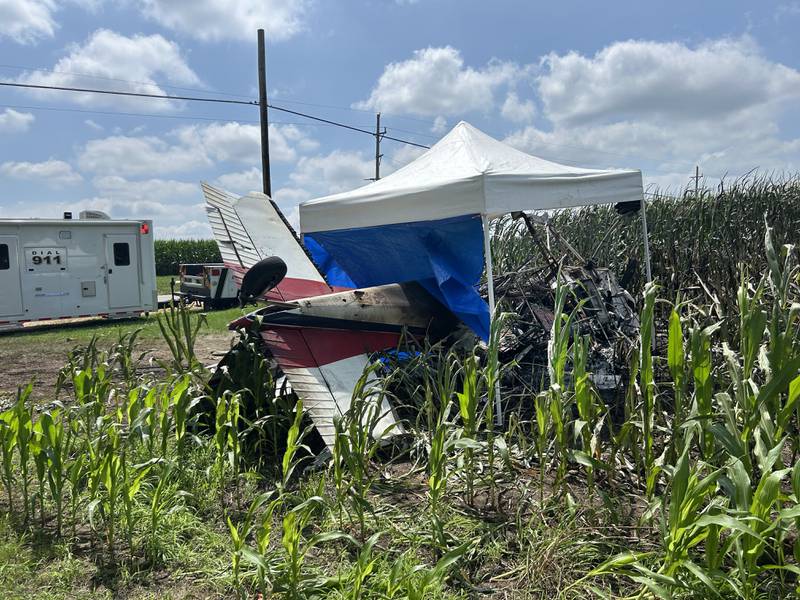 A crop dusting plane lies upside down in the edge of a cornfield along Illinois Route 64 near the Ogle County Airport between Oregon and Mt. Morris on Tuesday, July 22, 2025. The pilot of the plane was killed after hitting power lines near the airport and crashing. A section of Illinois Route 64 remained closed between Rock and Ridge roads as ComEd crews worked to repair damage to poles and lines. This photo was taken after the pilot was removed from the wreckage.