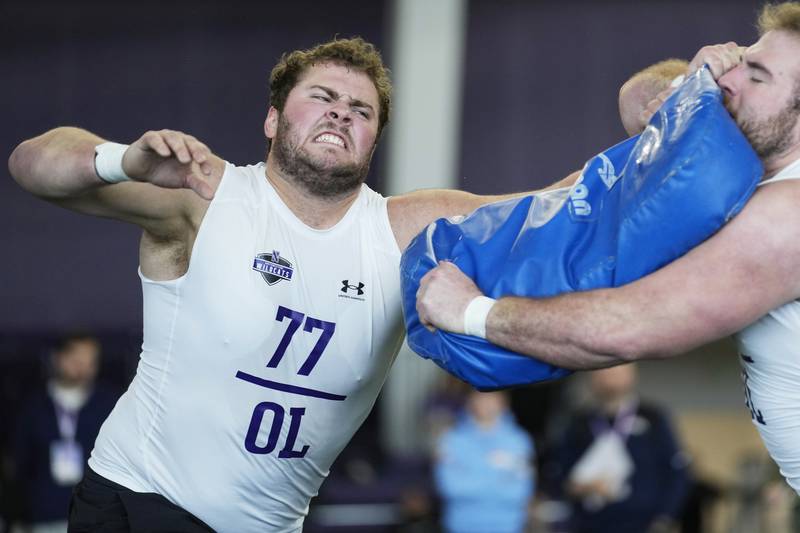 Northwestern offensive linemen Peter Skoronski (left) and Vince Picozzi participate in a position drill during Northwestern's Pro Day, Tuesday, March 14, 2023, in Evanston.