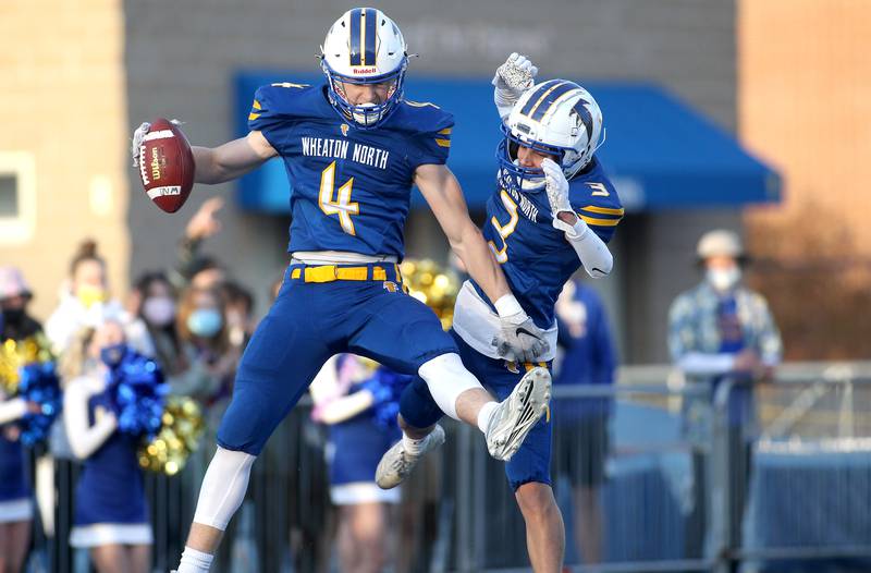 Wheaton North's Seth Kortenhoeven (4) and Gabe Parker (3) celebrate Kortenhoeven's touchdown during a game against Geneva at Wheaton North on Friday, April 16, 2021.