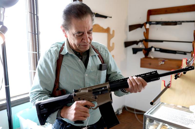 Manny Segarra of St. Charles holds the AR-15 rifle no longer for sale at his store, Manny Segarra Guns in West Chicago, on Wednesday, Jan. 11, 2023. Illinois Gov. JB Pritzker signed a bill Tuesday, Jan. 10, 2023 banning the purchase, sale and manufacture of high powered semi-automatic weapons, .50 caliber rifles and ammunition, and large-capacity magazines in the state while still allowing people who already own such weapons to keep them.