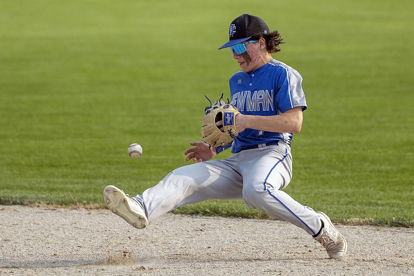 Newman’s Garret Matznick is knocked off balance by a hard shot at second but makes the play for an out against Amboy Thursday, May 18, 2023.