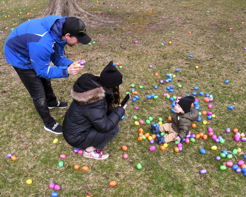 Andrew Gerdau gets the attention of his son Maverick Gerdau, 8 months, as his wife Samantha Gerdau takes a photo among the Easter eggs during the Easter Egg Hunt event held at Cantigny Park in Wheaton on Sunday March 24, 2024.