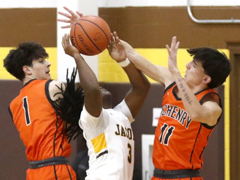 McHenry's Marko Visnjevac and Hayden Stone try to block the shot of Jacobs' Emaan Thomas as he drive to the basket during a Fox Valley Conference boys basketball game on Wednesday, Nov. 29, 2023, at Jacobs High School in Algonquin.