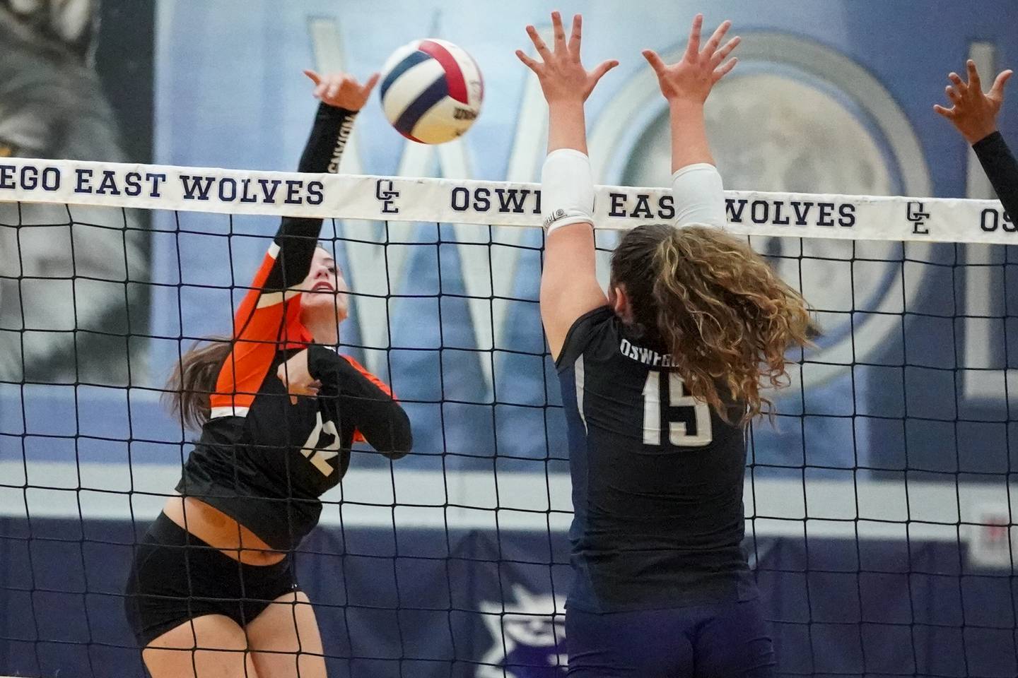 Minooka’s Courtney McCarthy (12) goes up for a kill attempt against Oswego East's Mia Stanley (15) during a Southwest Prairie Conference match in Oswego on Thursday, Sept. 18, 2025.