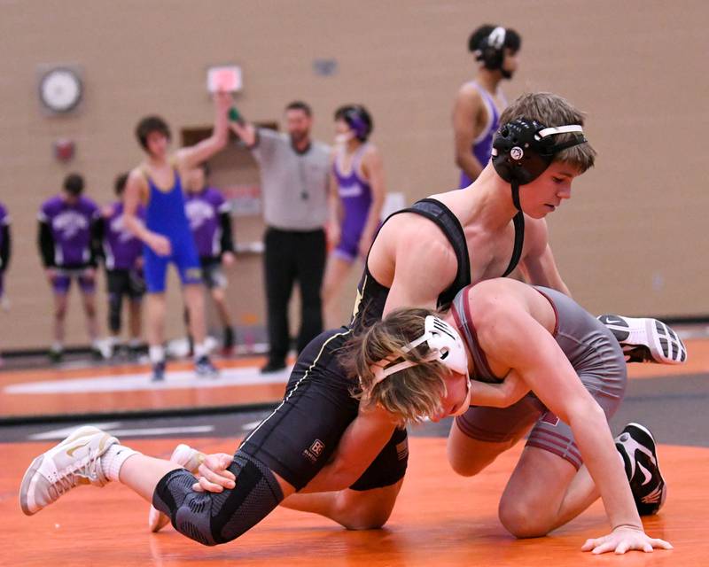 Liam Schroeder of Sycamore, left, tries to stay out of reach of the hands of Moline's wrestler Matthew Hoss in the 113-weight class on Tuesday Dec. 30, 2025, during the Flavin Invite held at DeKalb High School.