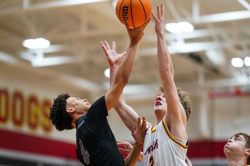 Oswego East's Myles Buchanan (4) and Downers Grove North's Jack Romsey (2) fight for a rebound during a Batavia Night of Hoops Basketball game at Batavia High School on Saturday, Jan. 25, 2025.