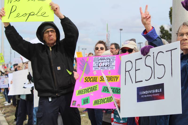Protesters wave as cars honk in support along Randall Road in Algonquin on April 5, 2025 during the "Hands Off" protest.