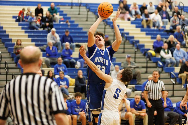 Wheaton North's Adam Schilling shoots a shot over Geneva's Jackson McCarthy on Friday, Feb.13,2026 in Geneva.