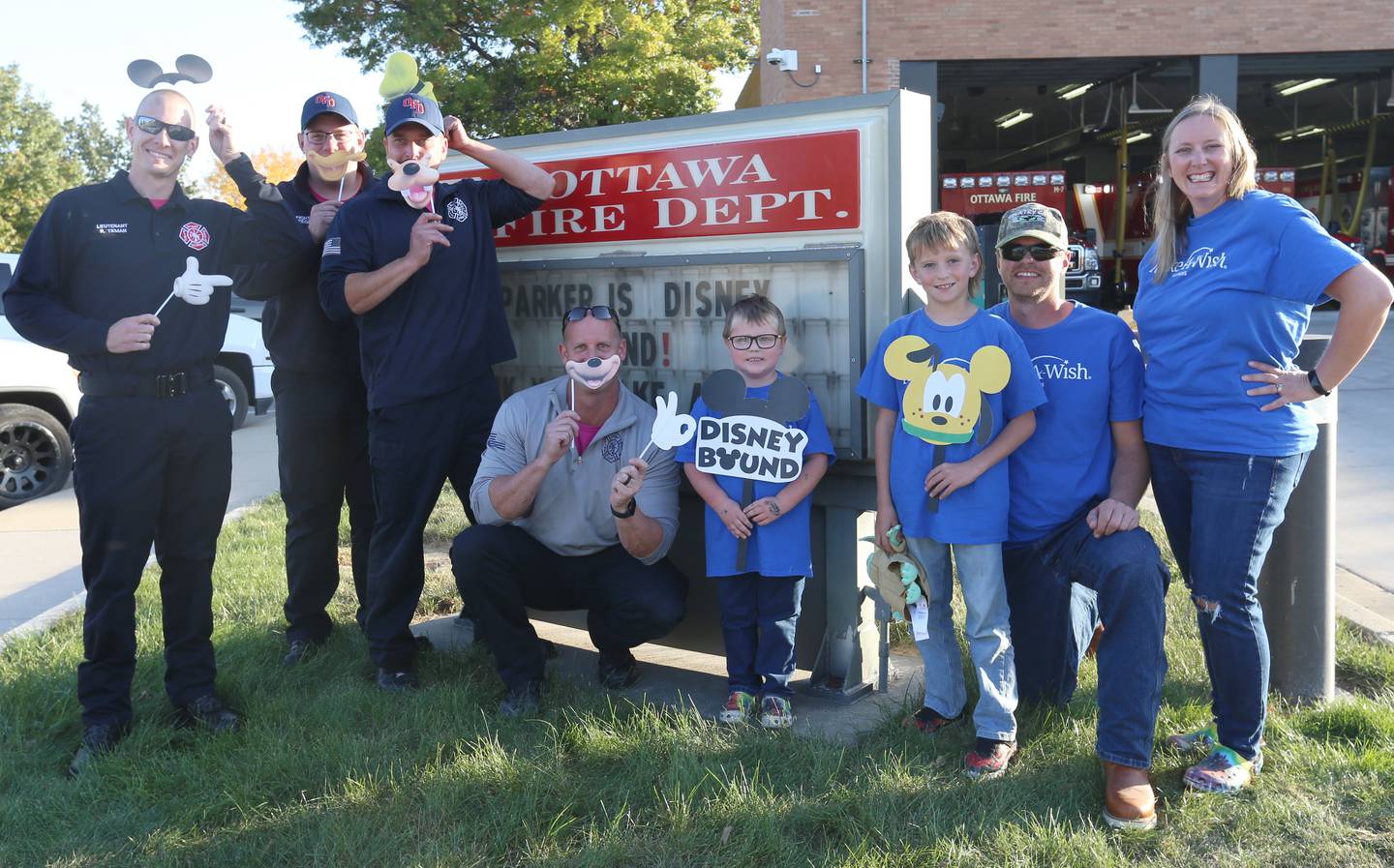 Parker Vangalder 6, (center) of Seneca, poses with Ottawa firefighters Ryan Teman, Mike Steege, Nick Allegretti, Lieutenant Kevin Theis and his family Colton, Brian, and Jennifer at the Ottawa Fire Department on Monday, Oct. 10, 2022. Vangelder and his family are going to Walt Disney World later this month.
