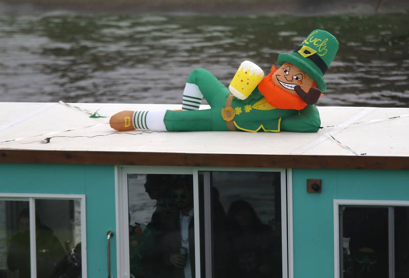 A leprechaun inflatable rides on top of a boat  on the Fox River  the dying of the river green during the McHenry’s ShamROCKS the Fox Festival on Saturday, March 14, 2026, in McHenry.