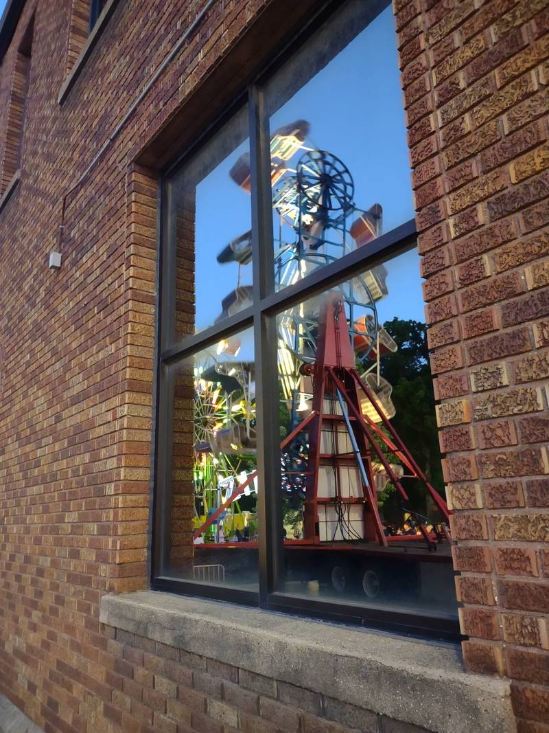 The Zipper carnival ride is reflected in the window of the building at the corner of Park and Hickory streets in downtown Streator during the opening night of Park Fest, Friday, May 26, 2023.