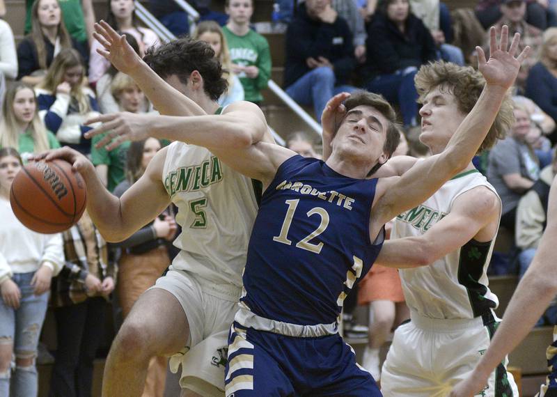Seneca’s Kysen Klinker and Kenny Daggett collide with Marquette’s Denver Trainor  while trying for a rebound Tuesday during the 2nd period at Seneca.