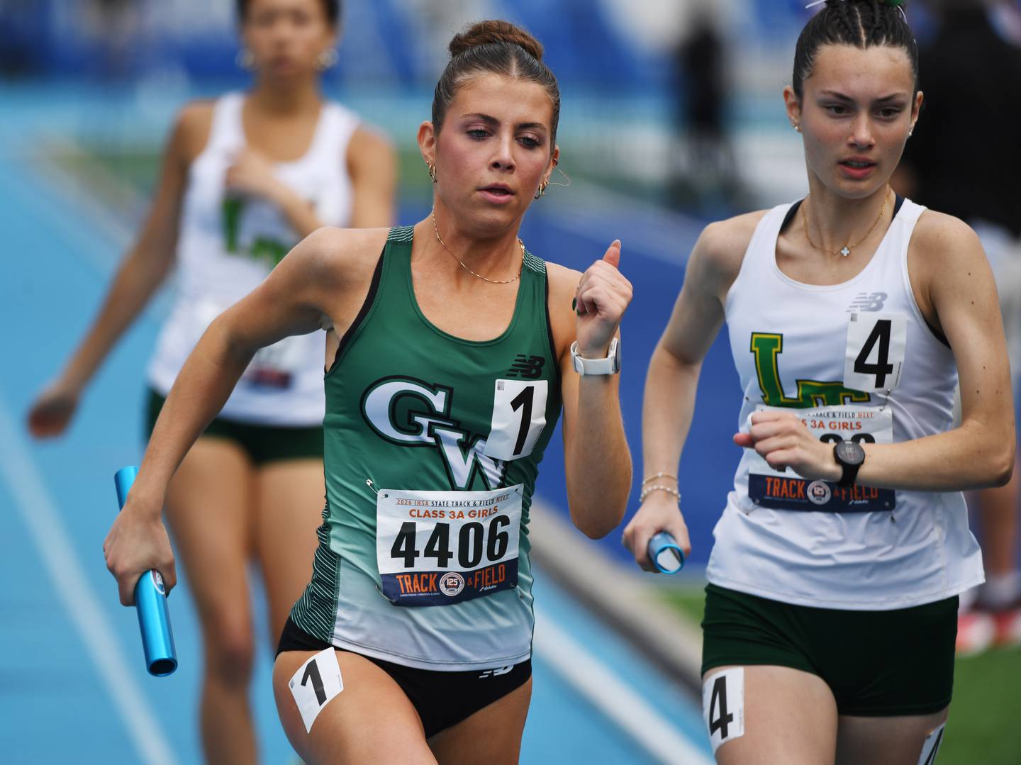 Glenbard West’s Alexa Novak, left, carries the baton for the Hilltoppers in the 3,200-meter relay during the Class 3A girls track and field state meet at Eastern Illinois University on Saturday, May 23, 2026 in Charleston.