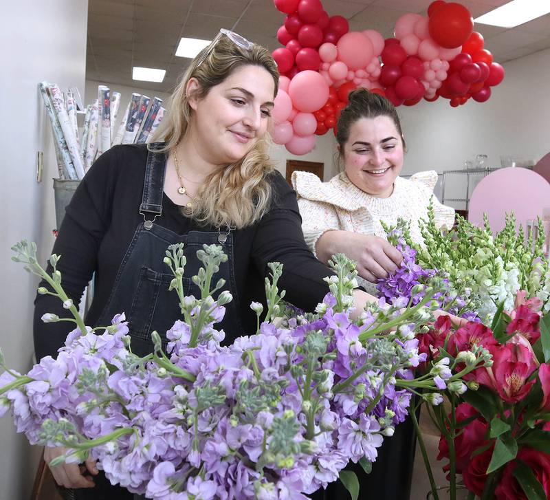 Kat Willrett (left) and Mary Grace McCauley, co-owners of Willrett Flower Company, get the shop set up Wednesday, Feb. 8, 2023, for Saturday’s Downtown DeKalb Sweet Stroll event. The event, which will take place from 1 to 4 p.m. Saturday, will see more than a dozen businesses play host to vendors of speciality sweets, as well as fun activities.