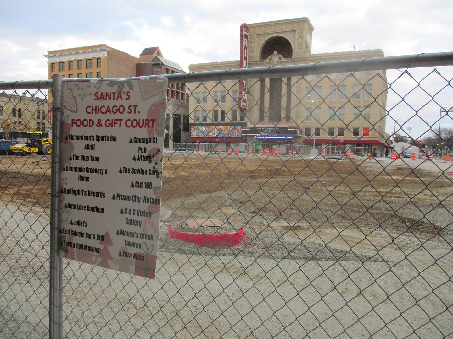 A sign posted on the fence that surrounds the construction site for the future city square advises visitors where they can shop and eat in the construction zone in downtown Joliet. Dec. 18, 2024