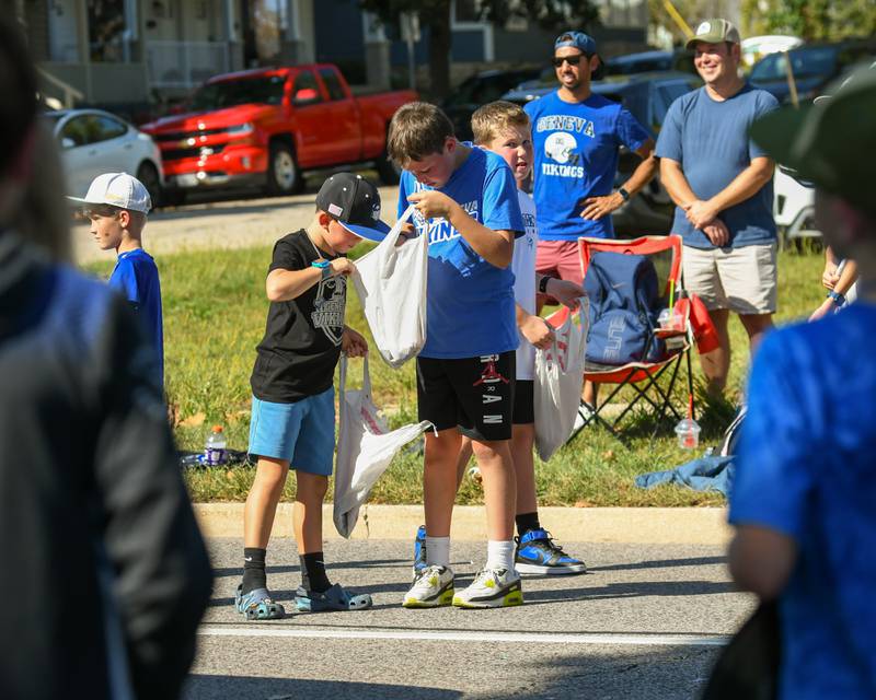 (From left) Friends Ryan Harke, 8, and Harrison Juska, 11, of Geneva, look through Harrison’s bag of treats to see what goodies he's collected during the Geneva High School Homecoming Parade on Friday, Sept. 26, 2025, along State Street downtown.