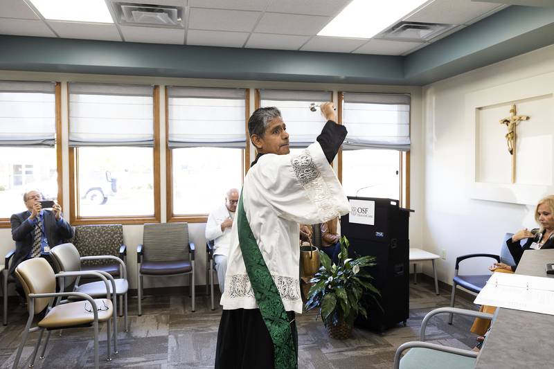 Deacon Armando Regalado blesses the newest OSF Saint Katharine clinic in Sterling with holy water Wednesday, Oct. 8, 2025.