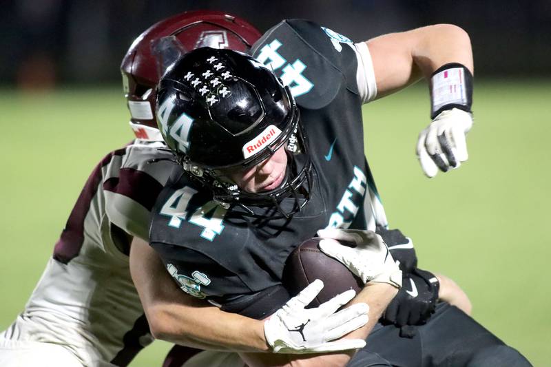 Marengo’s Hunter Muench tackles Woodstock North’s Brady Rogers in varsity football at Rod Poppe Field on the campus of Marengo High School in Marengo on Friday, Sept. 12, 2025.