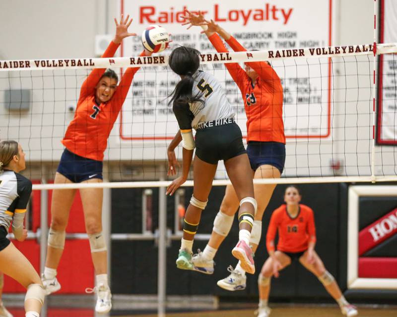 Oswego's Hannah Herrick (7) attempts a block on Joliet West's Mady Gant (5) spike during Class 4A Bolingbrook Sectional semifinal match between Joliet West at Oswego.  Nov 5, 2024  in Bolingbrook.