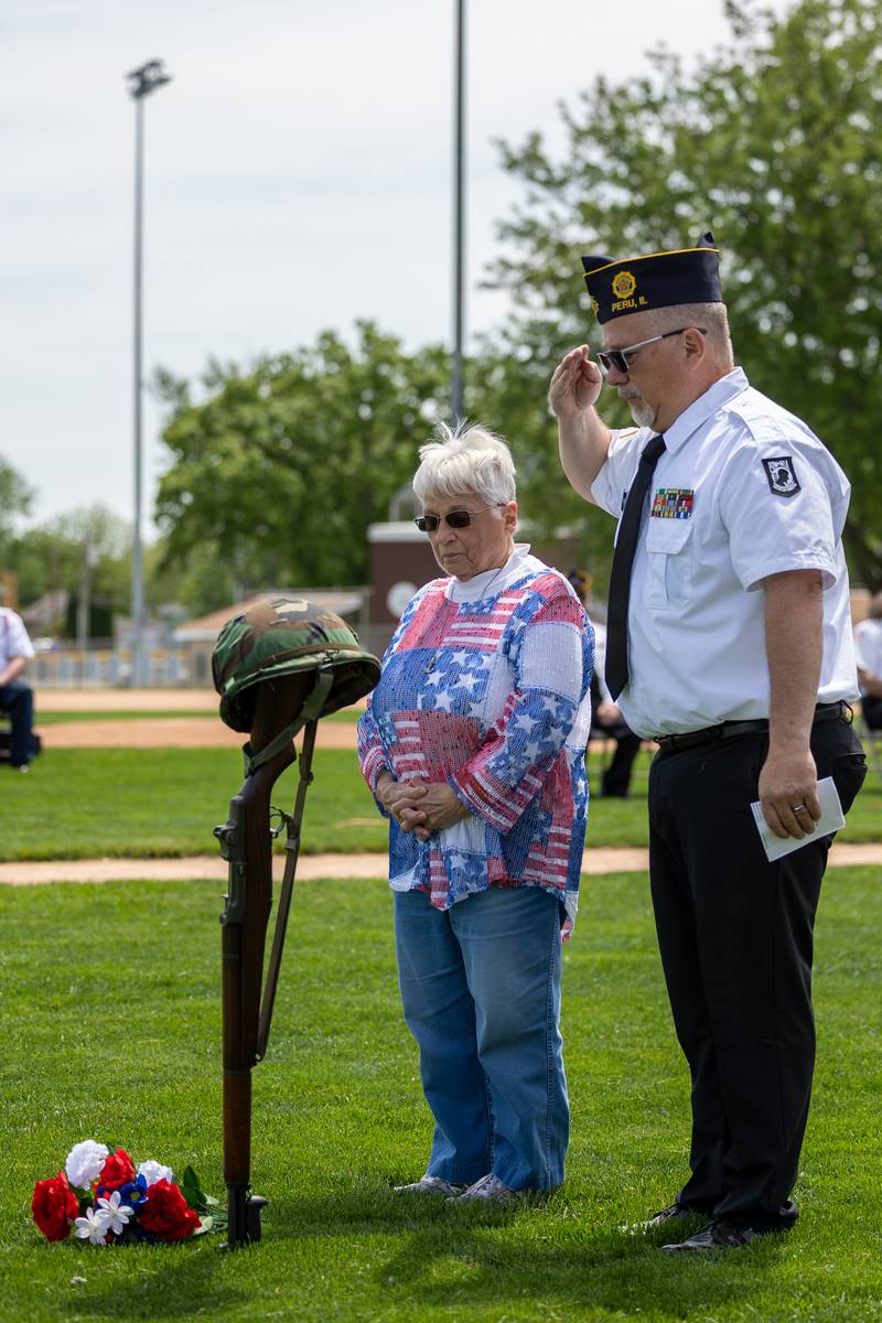 (left to right) Dennis Znaniecki of the Peru Honor Guard and Kathy Ankiewicz lay flowers in front of the soldiers cross on Monday, May 26, 2025 at Washington Park in Peru.