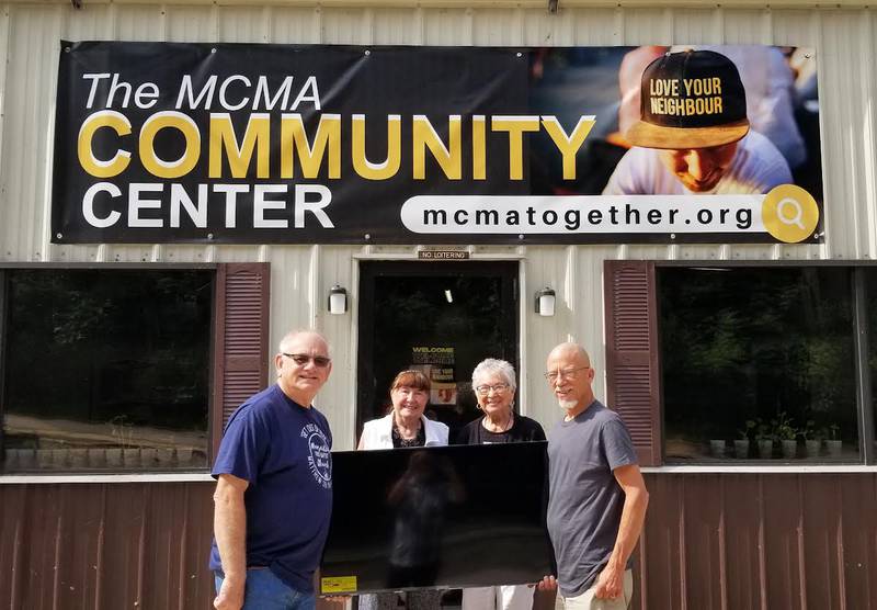 (Left to right) Marseilles Mayor Jim Hollenbeck, Rosemary Martin, Seattle Sutton and Pastor Troy Tvrdik (project developer and pastor of the First Baptist Church in Marseilles) hold up a TV donated by Rosemary Martin and Seattle Sutton to the Marseilles Community Center.