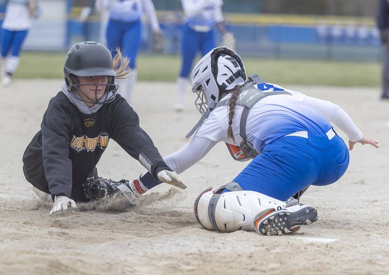 Newman’s Bostyn Ruch tags out Lena-Winslow’s Mackenzie Fink at home Wednesday, April 1, 2026.