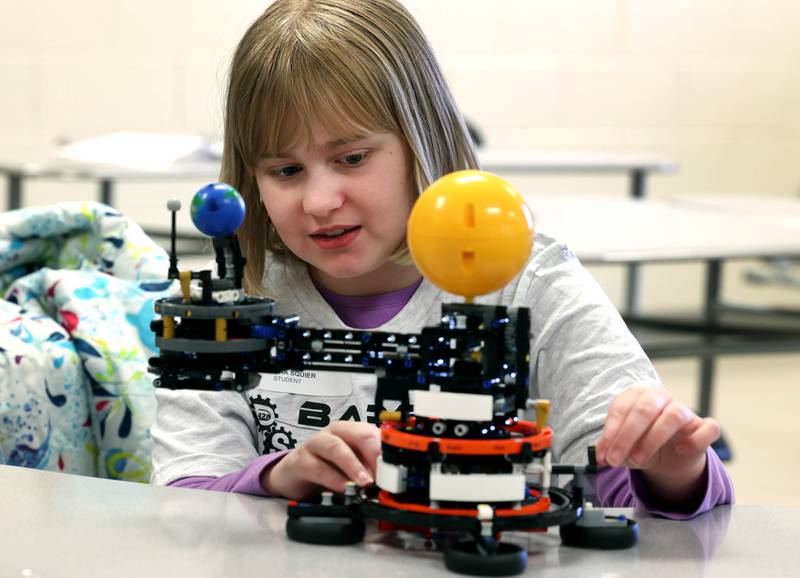 Nelora Squire, 10, from DeKalb, plays with a model Saturday, April 5, 2025, during a session put on by the Barb Brick Club at DeKalb High School. Squire was attending Meta’s Barb STEAMCon at the school which featured sessions focusing on the areas of science, technology, engineering, arts and math.