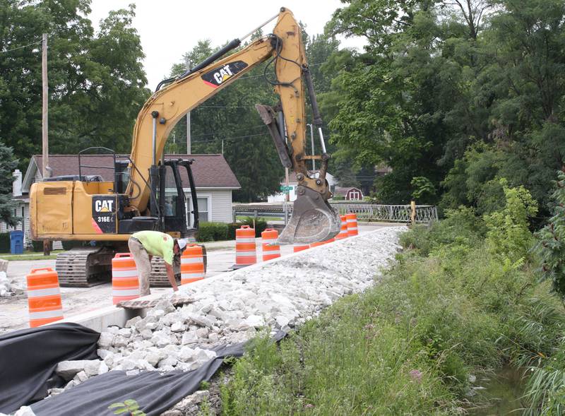 Crews replace rock along Clarks Run Creek on the site of the Utica retail plaza near the intersection of Mill and Grove streets on Wednesday, July 24, 2024 in Utica. Workers have begin replacing water lines, adding rock and preparing to redo the the Market on Mill area. The project is scheduled to be completed just before Burgoo.