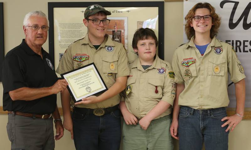 Utica Fireside White Sox Club member Randy Tuftie hands Boy Scouts of America Waltham Troop #797 scouts Aidan Dempsey, Tucker Morris and James Hoehn a donation during the 14th annual Utica Fireside White Sox Club donation presentation on Tuesday, Aug. 15, 2023 at the Utica Township Community Building. The scouts will use the money and regift the donation by buying and distributing presents to Veterans at the Illinois Veterans Home in La Salle this Christmas.