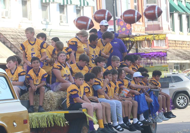 Members of the Mendota youth football team ride down Indiana Avenue during the homecoming parade on Friday, Oct. 3, 2025