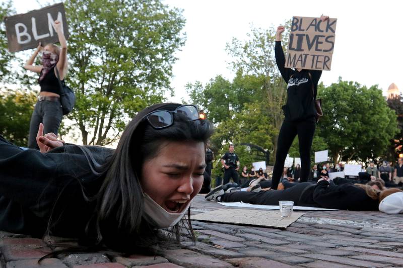 Julianna Schenker of Lakemoor, 15, yells "I can't breathe" while laying in the road with her hands behind her back, a situation that resulted in the death of George Floyd, during a Black Lives Matter protest on the historic Woodstock Square on Sunday, May 31, 2020 in Woodstock.