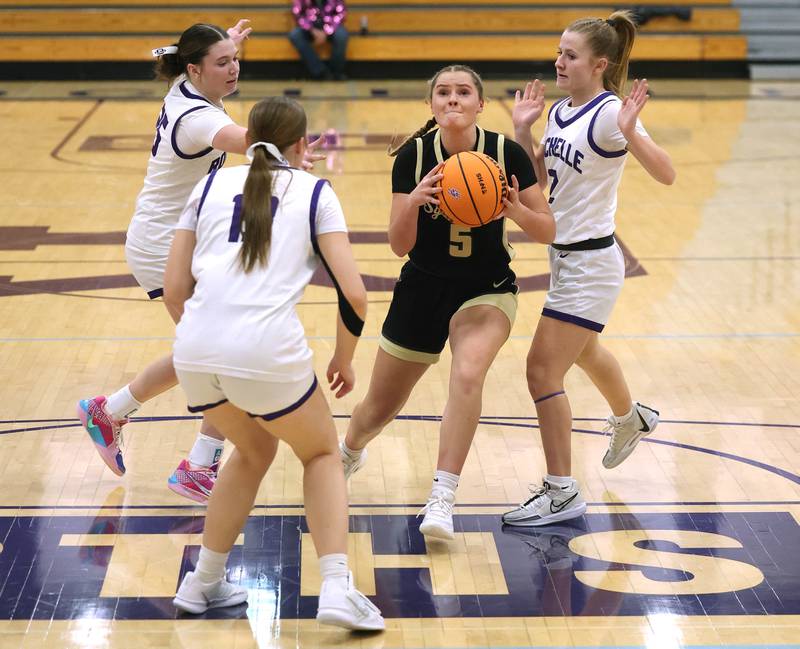 Sycamore's Grace Amptmann drives between three Rochelle defenders Friday, Dec. 5, 2025, during their game at Rochelle High School.