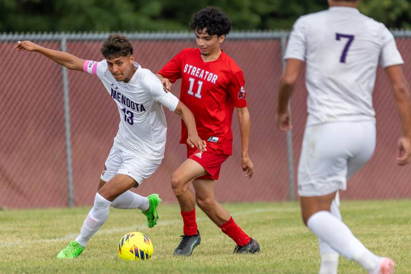(from left) Sebastian Carlos (13) of Mendota dribbles ball upfield with Adrian Granados (11) of Streator on his hip on Saturday, Aug 30, 2025 at the James Street Recreation Area in Streator.