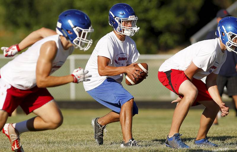 Dundee-Crown quarterback Pat Sprouse receives the snap during a 7-on-7 football scrimmage July 30 at Dundee-Crown High School in Carpentersville.