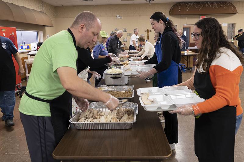 Joey Sagel serves up the the star of the meal, the turkey,  to volunteer Emma Halla Thursday, Nov. 24, 2022 in Dixon.