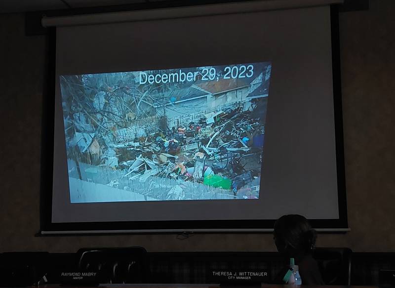 The Princeton City Council watches a slideshow Tuesday, Jan. 2, 2023, of a house on the 500 block of North Chestnut Street that has compiled junk and become a nuisance, according to residents of the neighborhood.