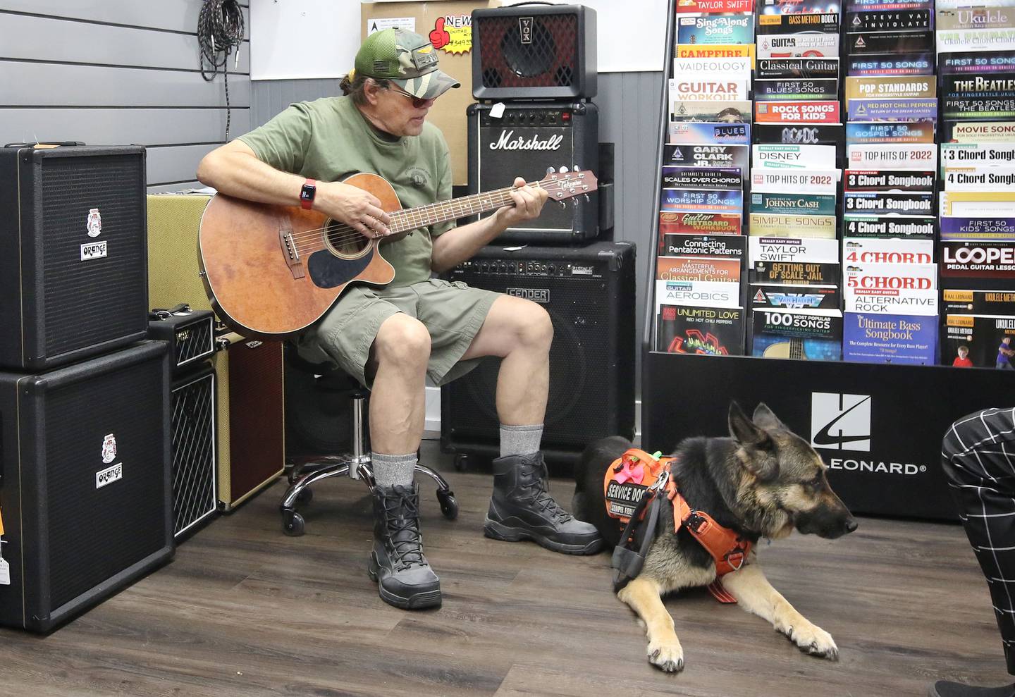 U.S. Marine Corps veteran Marshall Boyle, from DeKalb, plays guitar with his German Shepherd service dog, Lucy, Friday, Sept. 22, 2023, at Aurora Music Company in DeKalb. Boyle serves as an ambassador to Guitars 4 Vets and volunteers for Habitat for Humanity.