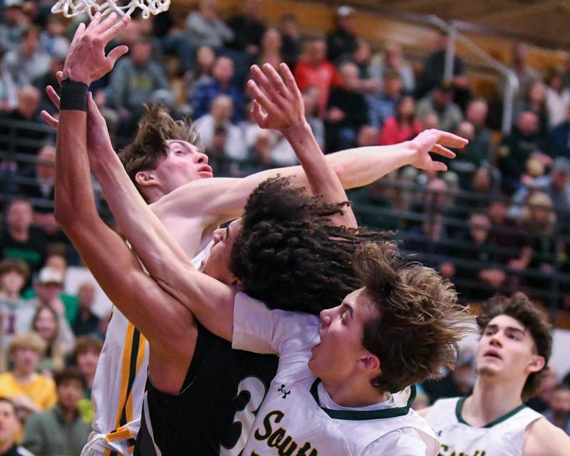 Kaneland's Evan Frieders, center, gets defended by Crystal Lake South's James Carlson, left, and Crystal Lake South's Anthony Santarelli (22) during the sectional championship game on Friday March 1, 2024, held at Kaneland High School.