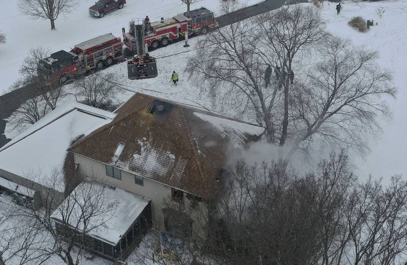 Ottawa firefighters (left) use their aerial fire engine to extinguish a structure fire on Friday, Jan. 10, 2025 at a residence located in the 2500 bock of East 1569th Road (Covel Bluff Lane) in Ottawa. The fire was upgraded to the second alarm. Firefighters from Oglesby, Utica, Grand Ridge, Marseilles, Tonica and others assisted with the fire.