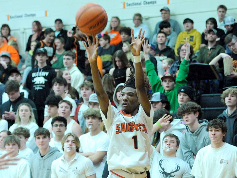 Sandwich's Simeion Harris (1) takes and makes a three-point shot against Plano during a varsity basketball game at Sandwich High School on Tuesday, Feb. 13, 2024.