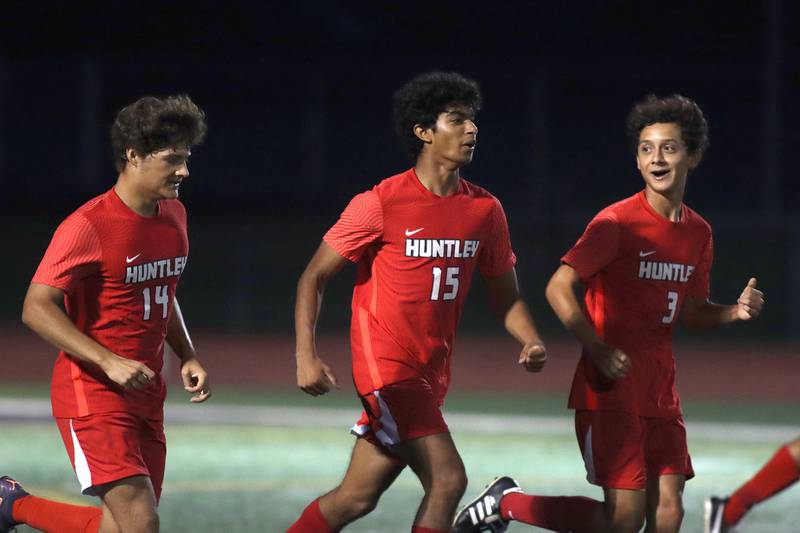From left, Huntley’s John Lengle, Ansel Dias and Elias Ramon trot back to restart the game after a Dias goal against McHenry in boys soccer Thursday, Sept. 15, 2022, in Huntley. The host Red Raiders won 2-0.