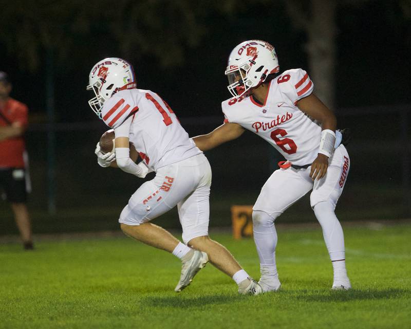 Ottawa's Colby Mortenson hands the ball to Archer Cechowicz against Kaneland on Friday, Sept. 22, 2023 in Maple Park.
