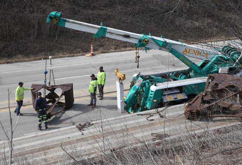 Crews with Senica Towing work the scene of a semi that struck the 7th Street bridge over Illinois Route 251 on Monday, March 10, 2025 in Peru. The semi was hauling two clamshell buckets for excavating equipment.